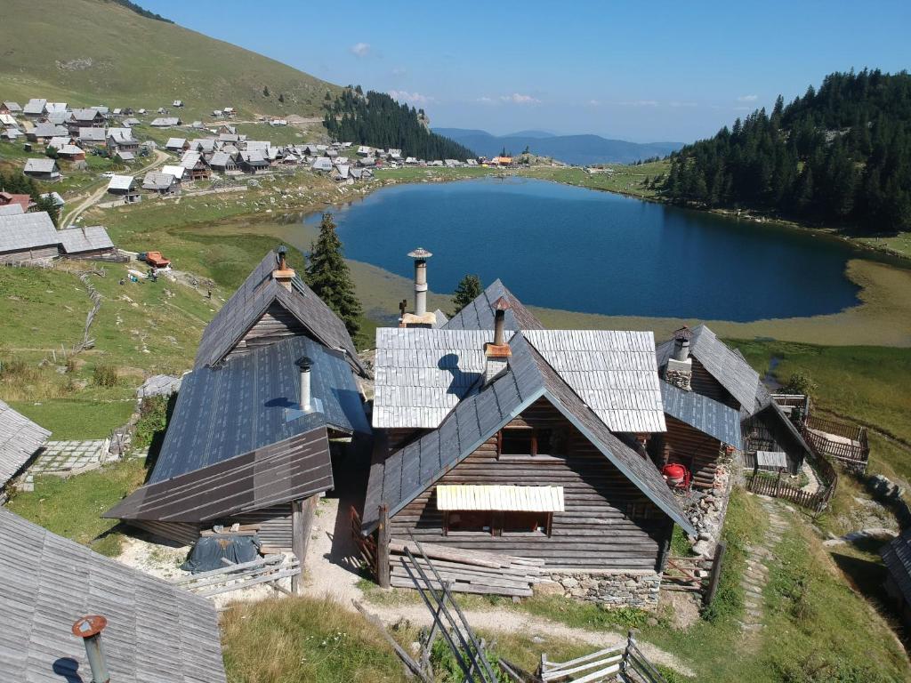 福伊尼察Koliba - Prokoško jezero的享有湖畔山丘上房屋的空中景致