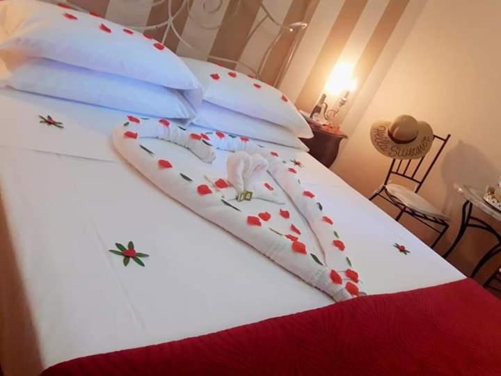 斯卡法蒂POMPEI HOUSE的一张白色的床,上面有红色的鲜花