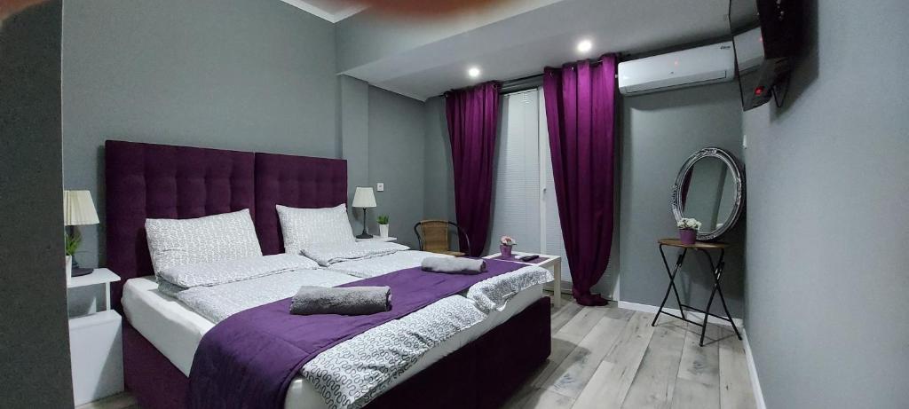 德米尔卡皮亚Villa Bratislava的一间卧室配有一张紫色的床和镜子