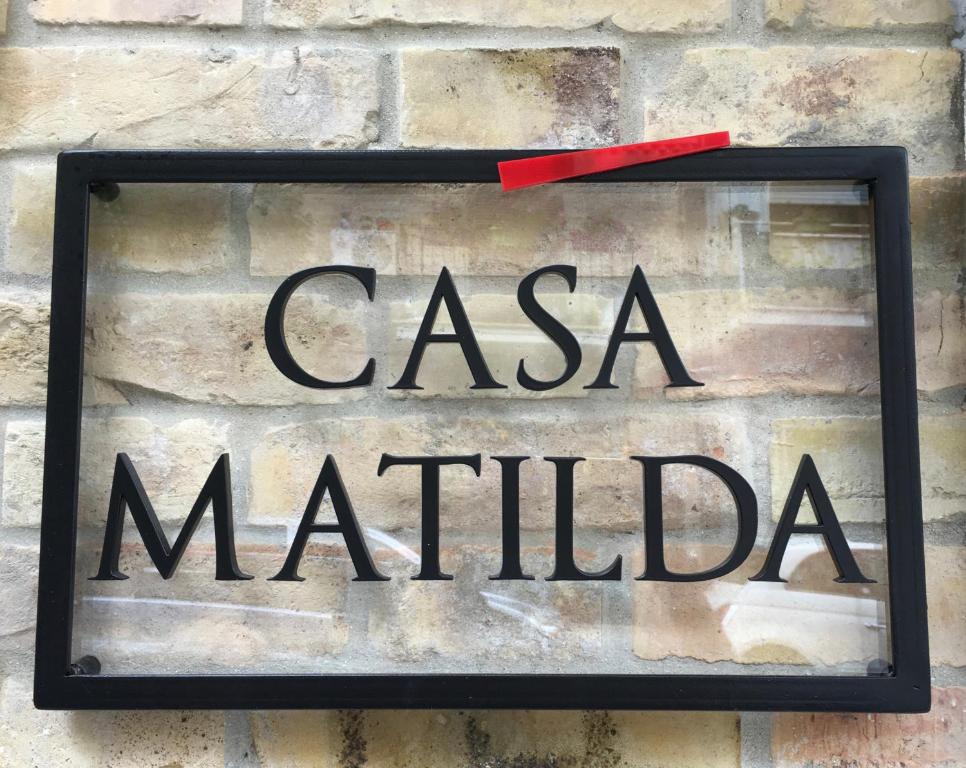 波尔图桑特埃尔皮迪奥Casa Matilda的砖墙上的一个标志,上面写着casa matilda的字