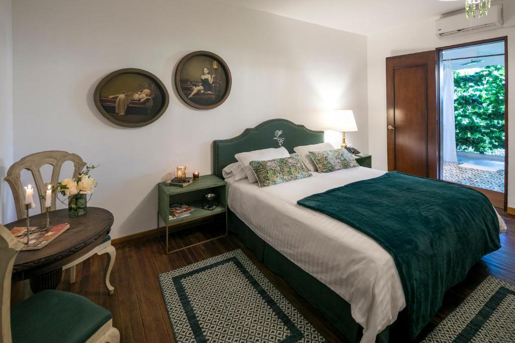 卡利Leclerc Hotel Boutique Cali Granada的一间卧室配有一张床、一张桌子和一个窗户。