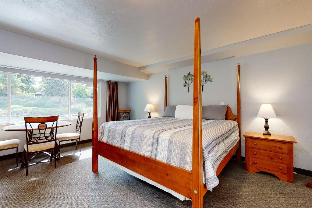 本德Deschutes Riverside Escape的一间卧室配有一张床、一张桌子和一个窗户。