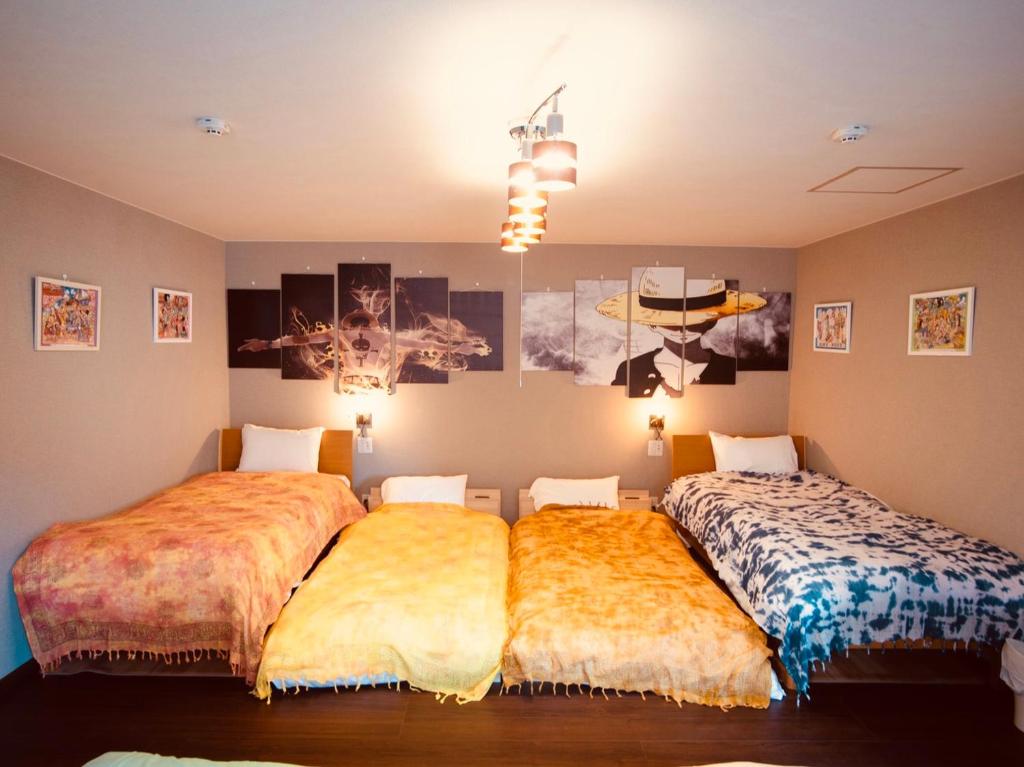 函馆Tomoeドットコム2 onepiecehouse的一间卧室配有两张带床罩的床。