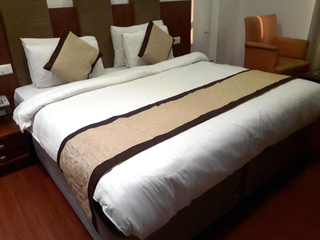 新德里Airport Hotel Golden Bliss Near Delhi Airport的一张大床,位于酒店客房内