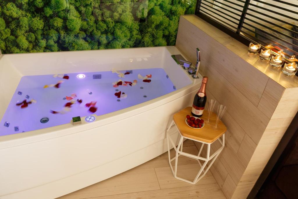 伊万诺-弗兰科夫斯克Luxury apartments «Love Story»的浴缸、一瓶香槟和一张小桌子