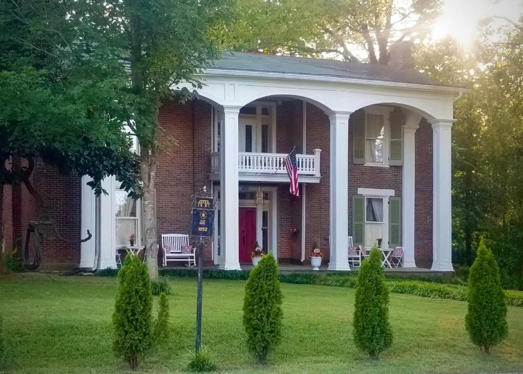 谢尔比维尔Belmont Inn的院子里有美国国旗的红砖房子