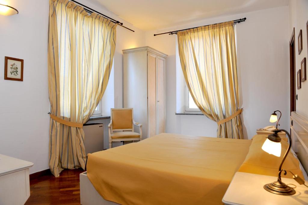 萨维尼奥内阿尔伯格比尔塔酒店的卧室配有床、椅子和窗户。