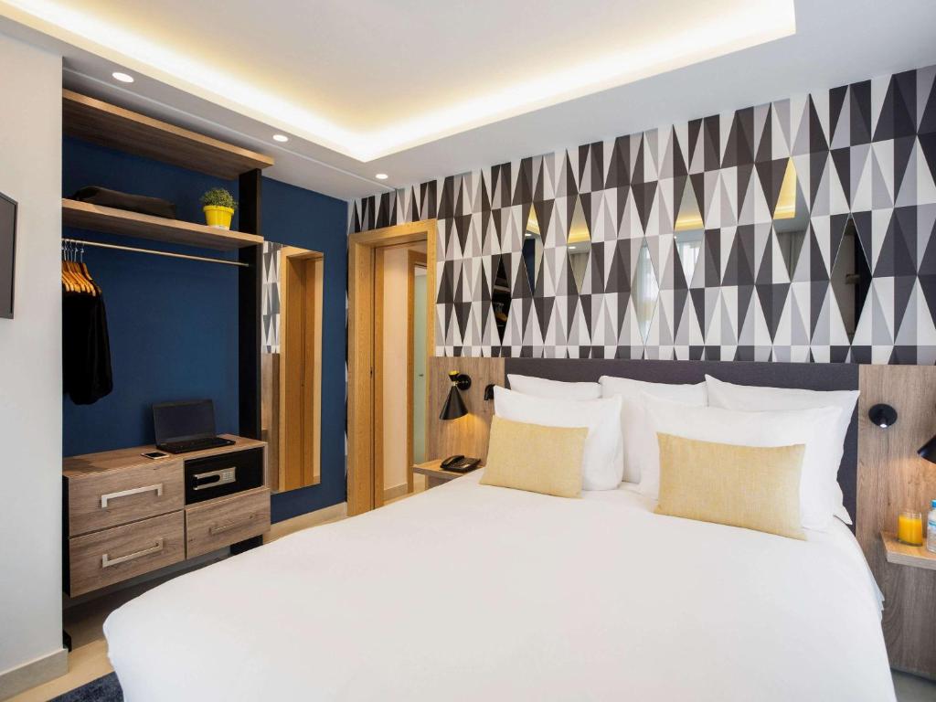 卡萨布兰卡Aparthotel Adagio Premium Casablanca City Center的卧室配有白色大床和蓝色的墙壁