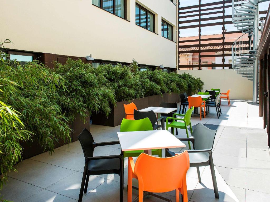 旺德尔港科利尤尔旺德尔港宜必思尚品酒店的户外庭院设有桌椅和植物