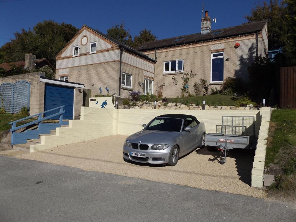 多切斯特Family guest suite in Cheselbourne的停在房子前面的银色汽车