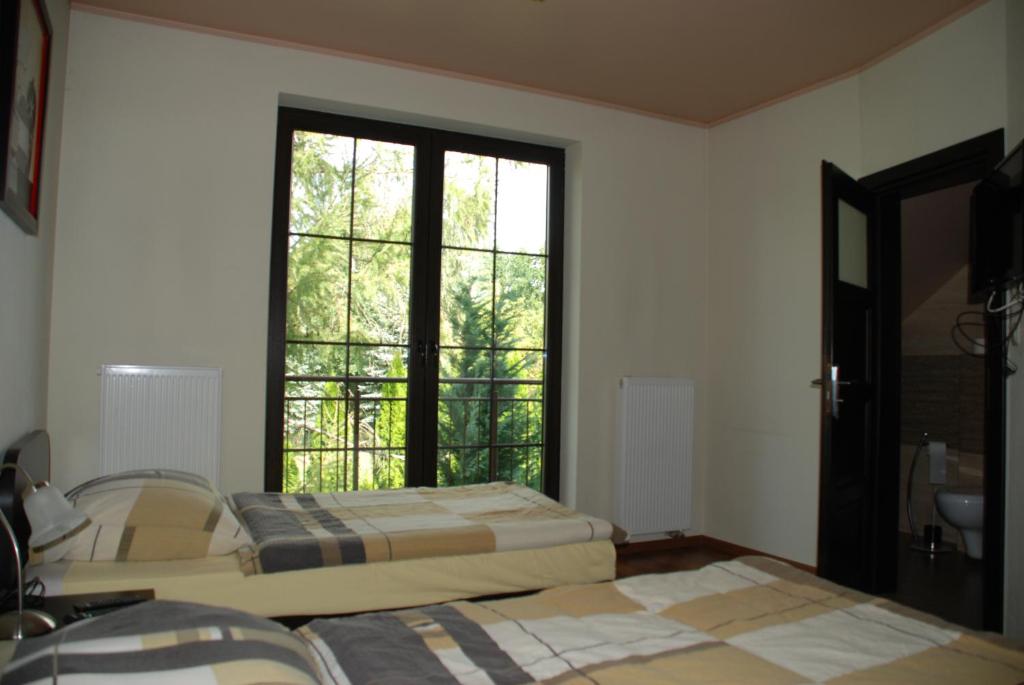 纳达金VillaRenoma的客房设有两张床和大窗户。