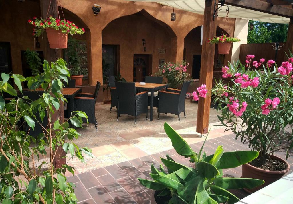 埃格尔Hacienda Apartmanok的户外庭院设有桌椅和鲜花