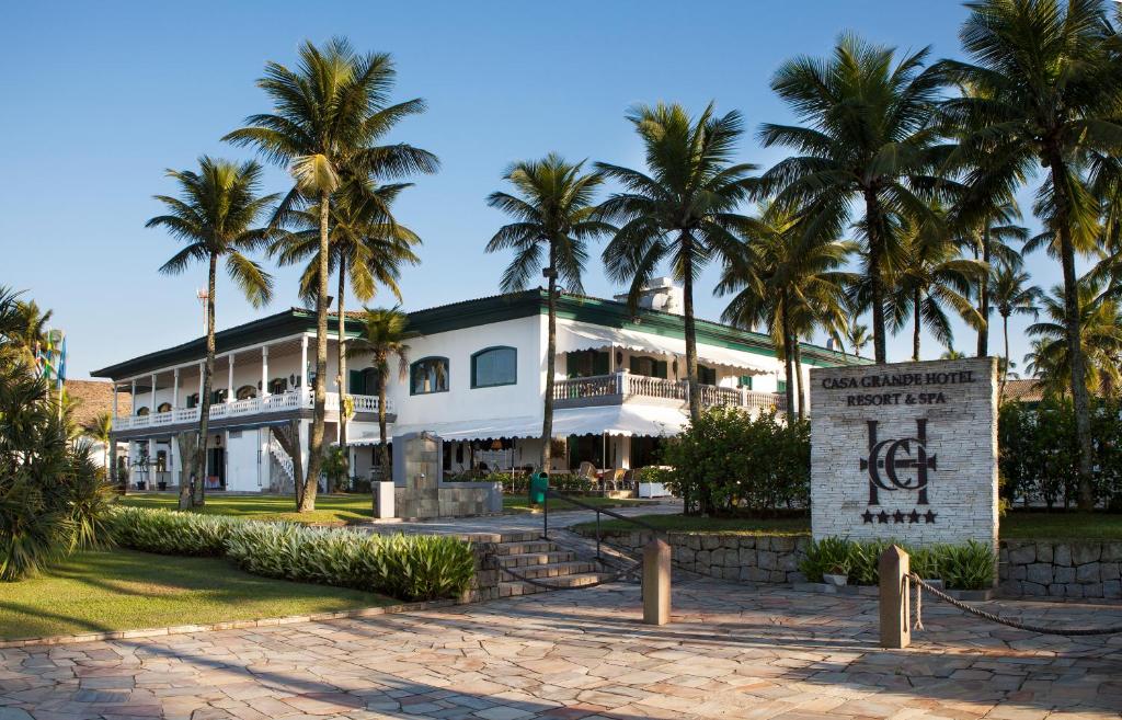 瓜鲁雅格兰德之家Spa度假村的一座棕榈树环绕的大型白色建筑
