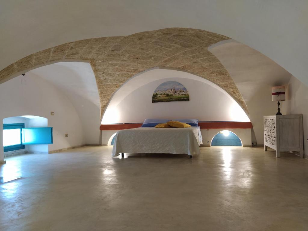 乌真托Corte Del Campanaro的一间带一张床铺的卧室,位于一个拱形的房间