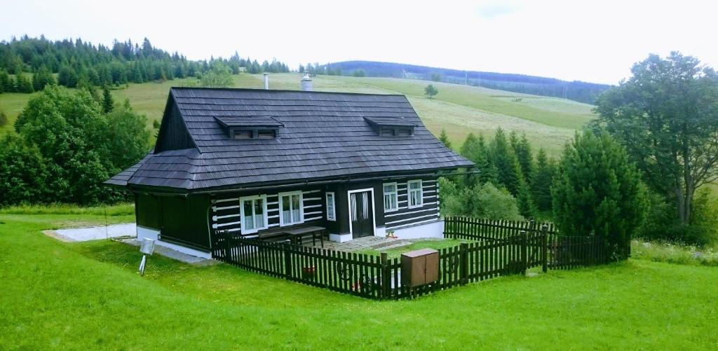 兹蒂尔Drevenica Goralský Dvor的绿色田野上带黑色屋顶的小房子