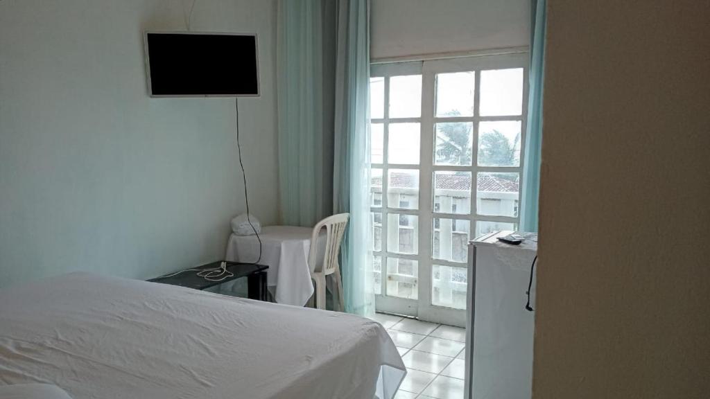 尼西亚弗洛雷斯塔Pousada Solar di Poletti的一间卧室设有一张床,享有窗户的景色