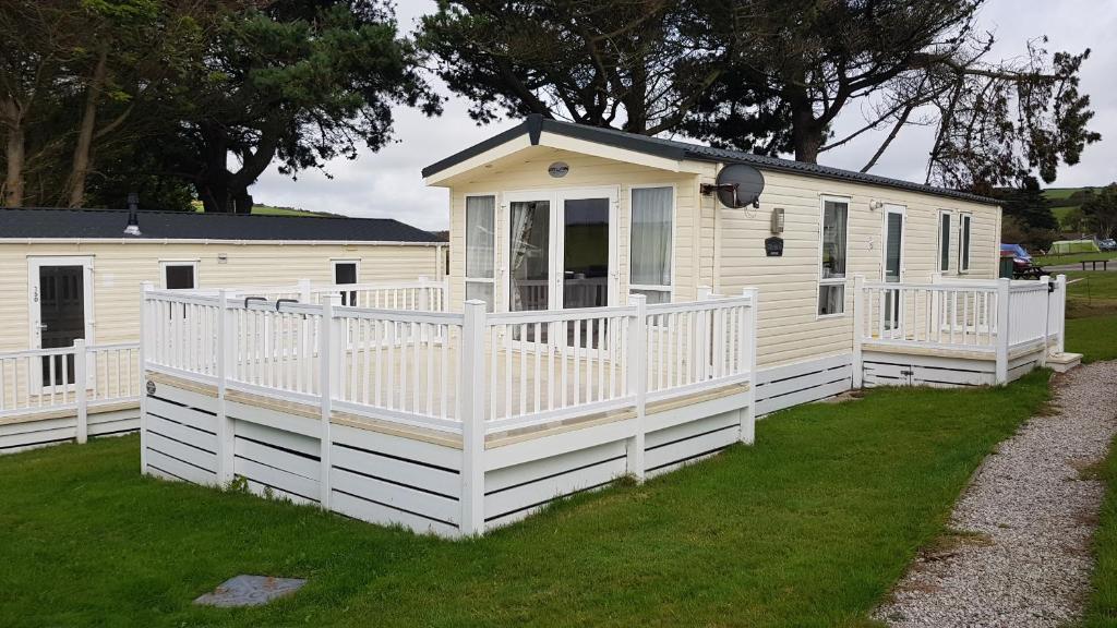 纽基Newquay Bay Resort 151的白色移动房屋 - 带门廊和围栏