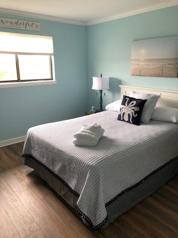希尔顿黑德岛Vacation Bliss LLC的卧室配有带枕头的大床和窗户。