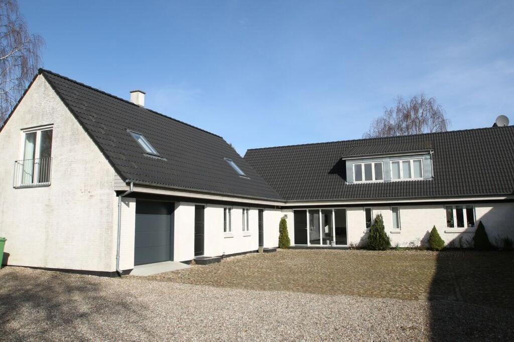 HarlevStenbrogård的黑色屋顶的大型白色房屋