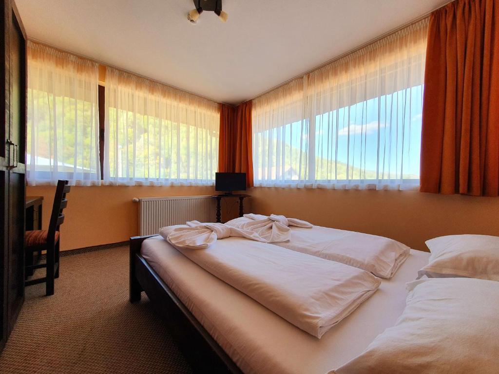 奇夫利克Family Hotel Chiflik Hills的一间卧室配有一张带白色床单和窗户的床。