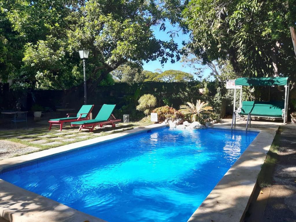 圣斐利-银港Villa Carolina Bed and Breakfast的蓝色游泳池旁设有蓝色躺椅