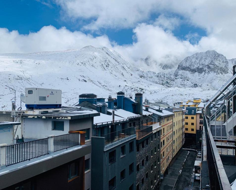 帕斯底拉卡萨AC Apartaments Centre的从大楼内可以欣赏到积雪覆盖的山脉美景