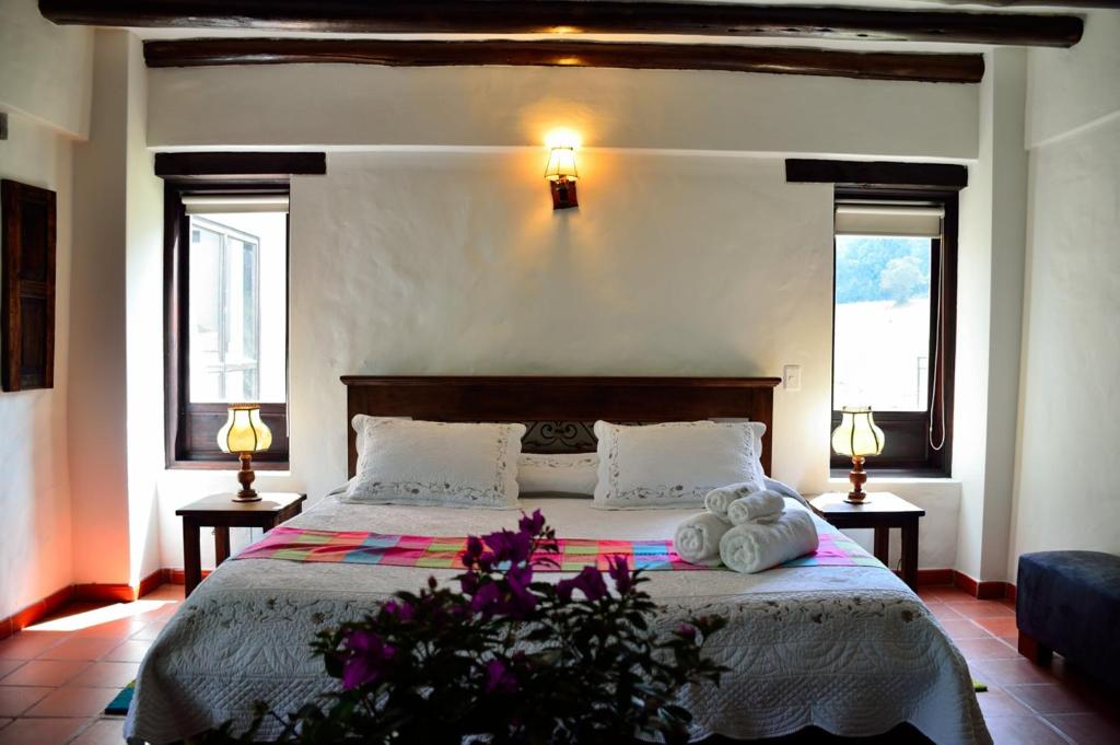 MadridLa Posada De Los Arcángeles的一间卧室配有带2条毛巾和2个窗户的床