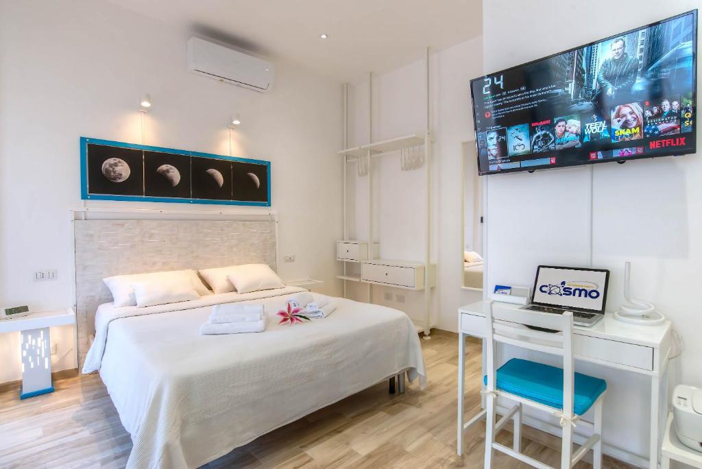 罗马Appartamenti LUNA e SOLE的卧室配有一张床,墙上配有电视。