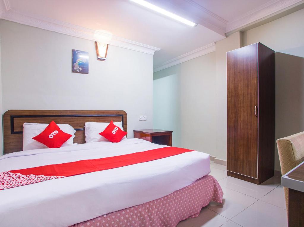 黑风洞Super OYO 89363 Casavilla Hotel的一间卧室配有一张带红色枕头的大床