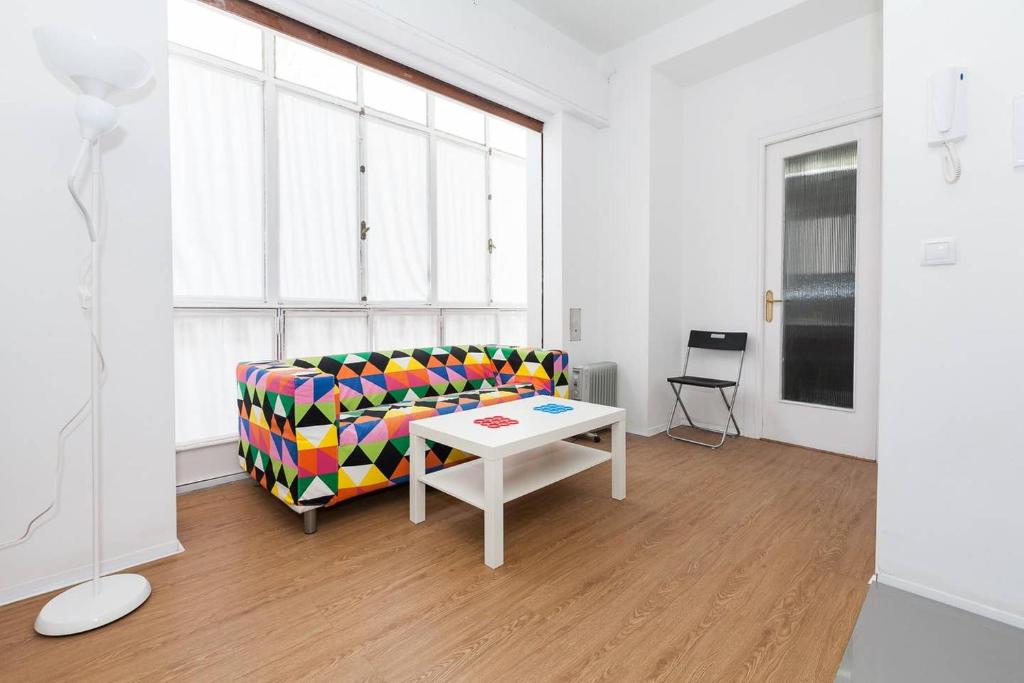 塞维利亚Apartamentos San Roque的客厅配有沙发和桌子