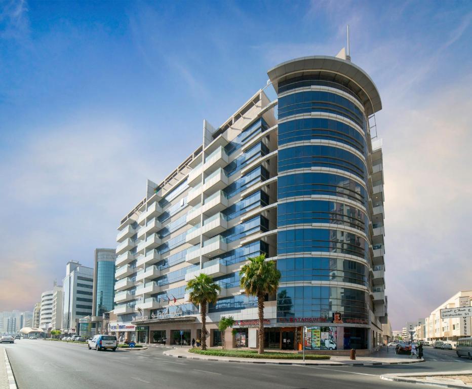 迪拜德拉星光大都市公寓酒店的一条城市街道上一座高大的建筑,顶部圆圆