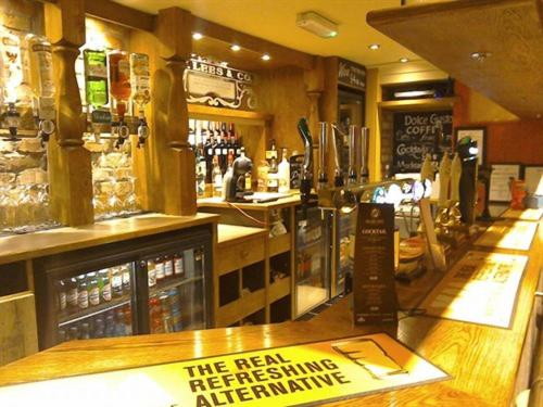 LlanfachraethHolland Hotel的餐厅设有酒吧,柜台上设有标牌