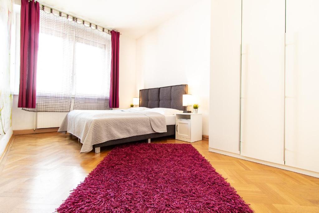 维也纳Apartment Mandlgasse I contactless check-in的一间卧室配有一张床和红色地毯