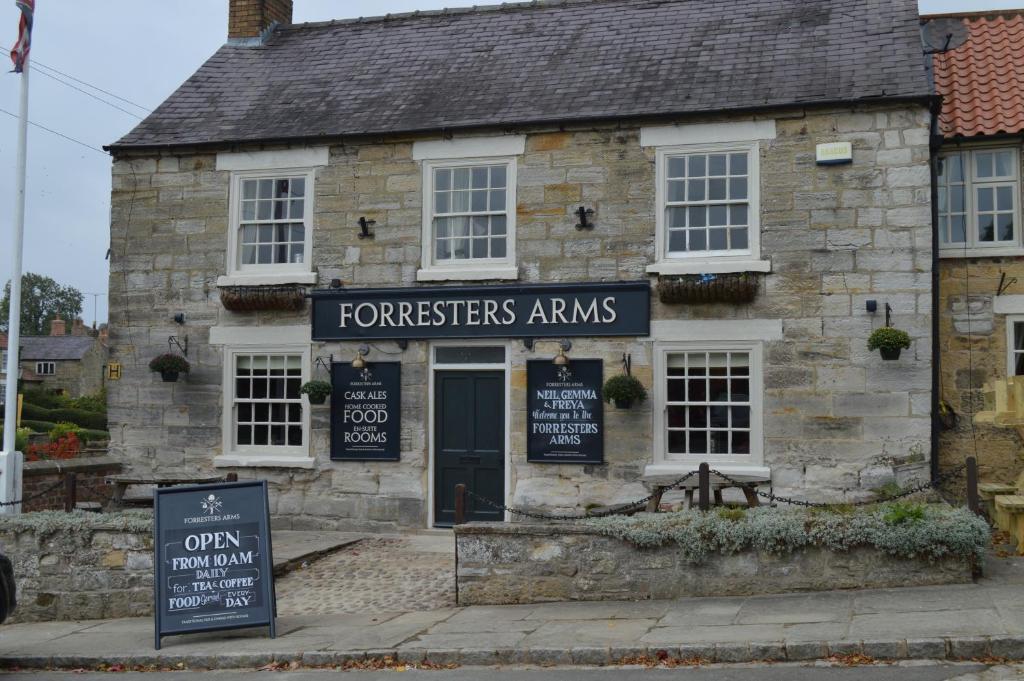 KilburnThe Forresters Arms Kilburn的一座古老的石头建筑,前面有标志