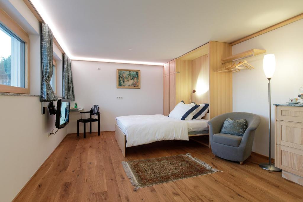 SchwarzachBusiness Apartment的配有一张床和一把椅子的酒店客房