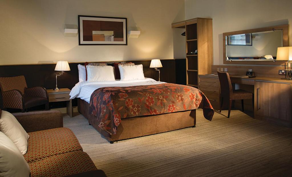 纽敦纳兹斯特兰福德纹章酒店的配有一张床和一张书桌的酒店客房