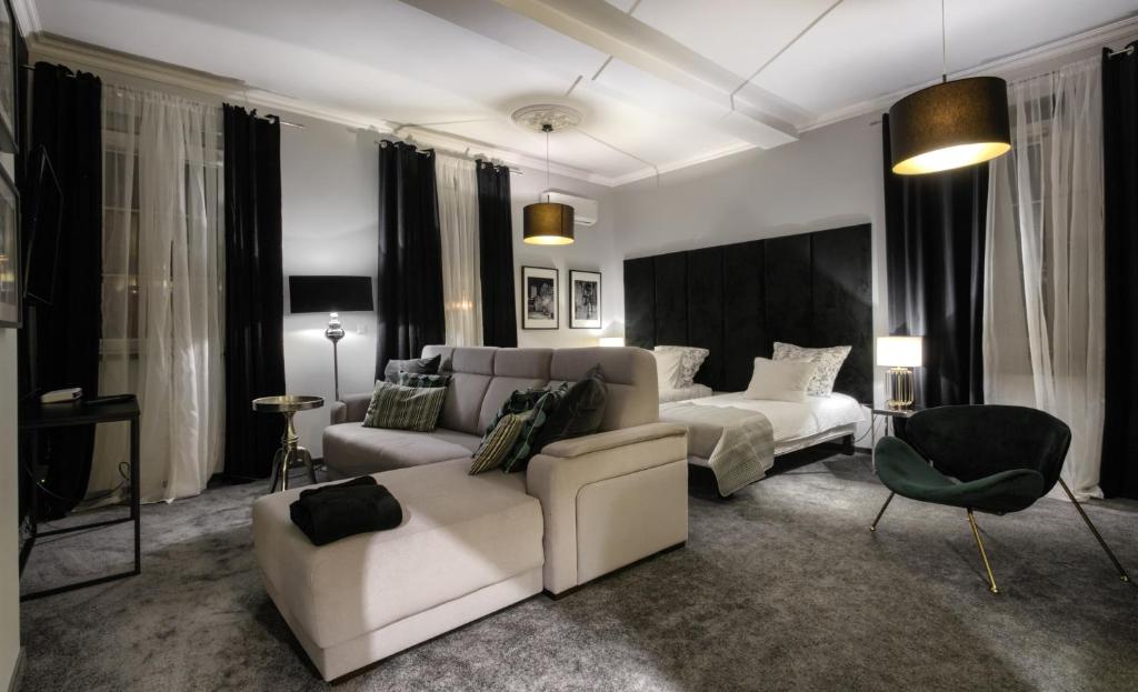 纳梅斯武夫Aparthotel & Restaurant Rezydencja Limba的客厅配有沙发和1张床