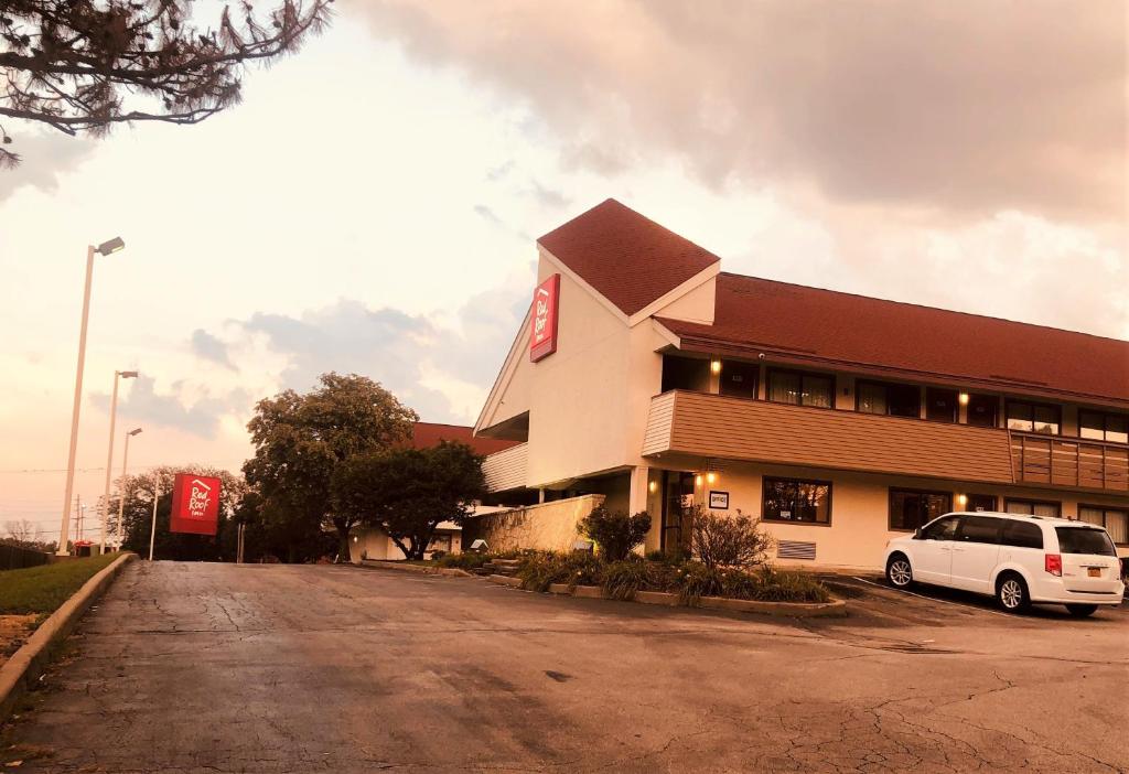 布里奇顿Red Roof Inn Bridgeton的停在大楼前的白色汽车