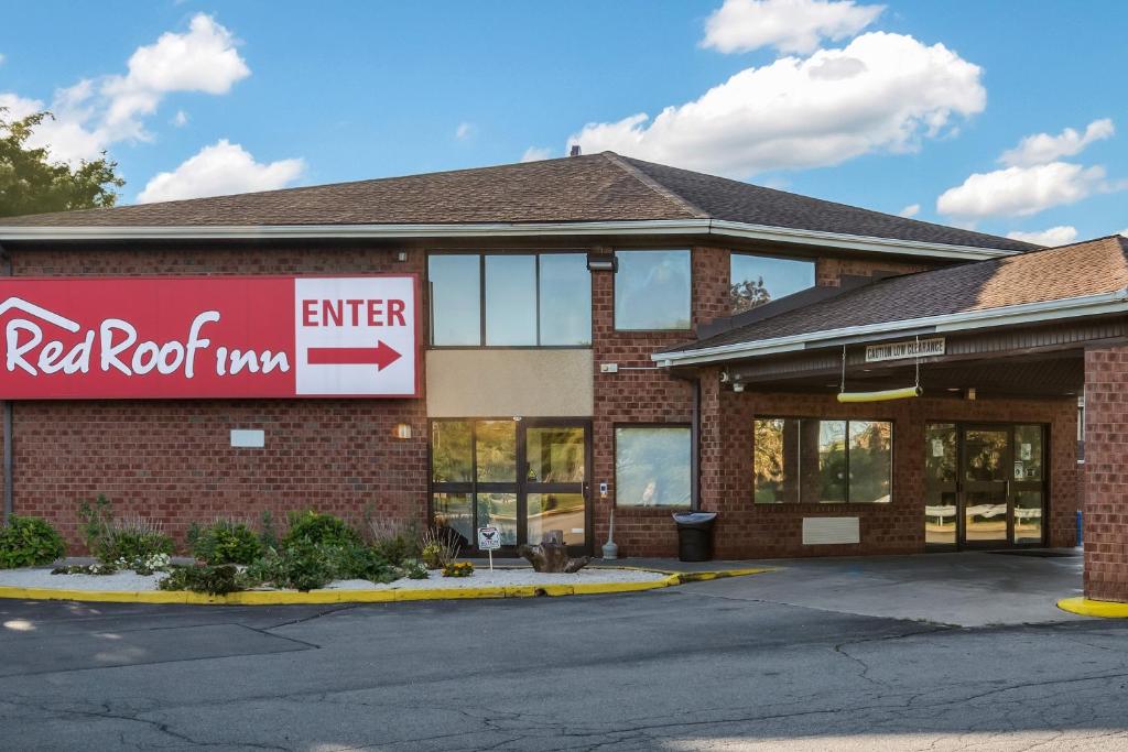 罗切斯特Red Roof Inn Rochester - Airport的红色岩石汽车旅馆大楼,设有红色屋顶