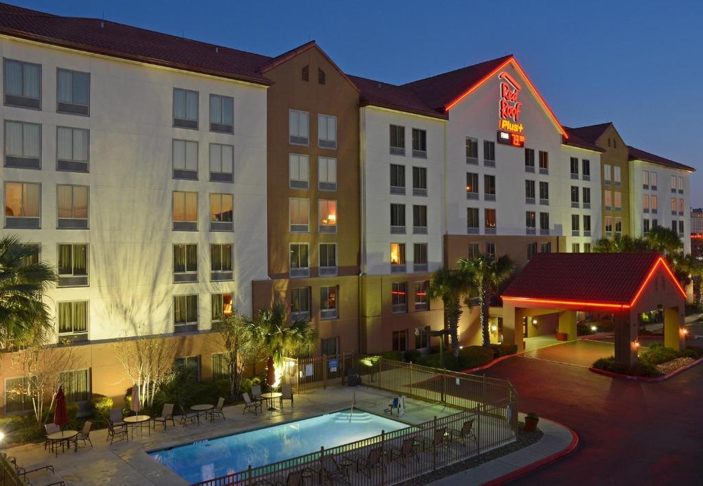 圣安东尼奥Red Roof Inn PLUS+ San Antonio Downtown - Riverwalk的享有酒店的景致,设有游泳池和桌子
