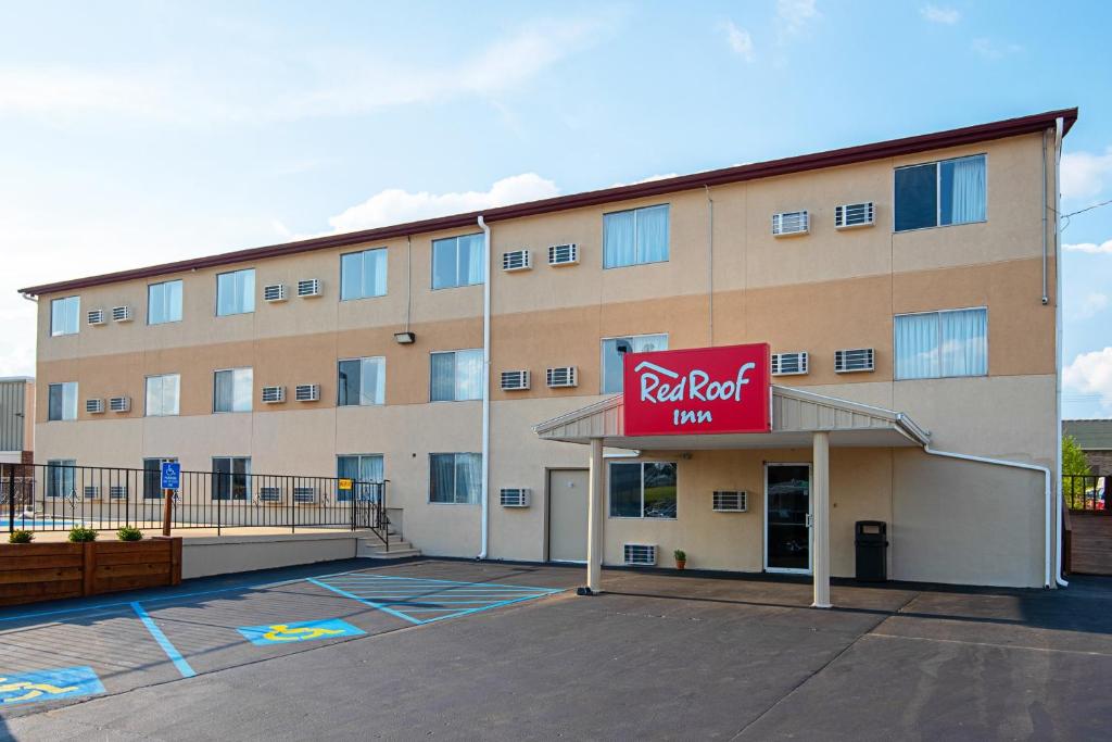 卡梅伦Red Roof Inn Cameron的停车场内有红色屋顶客栈标志的酒店