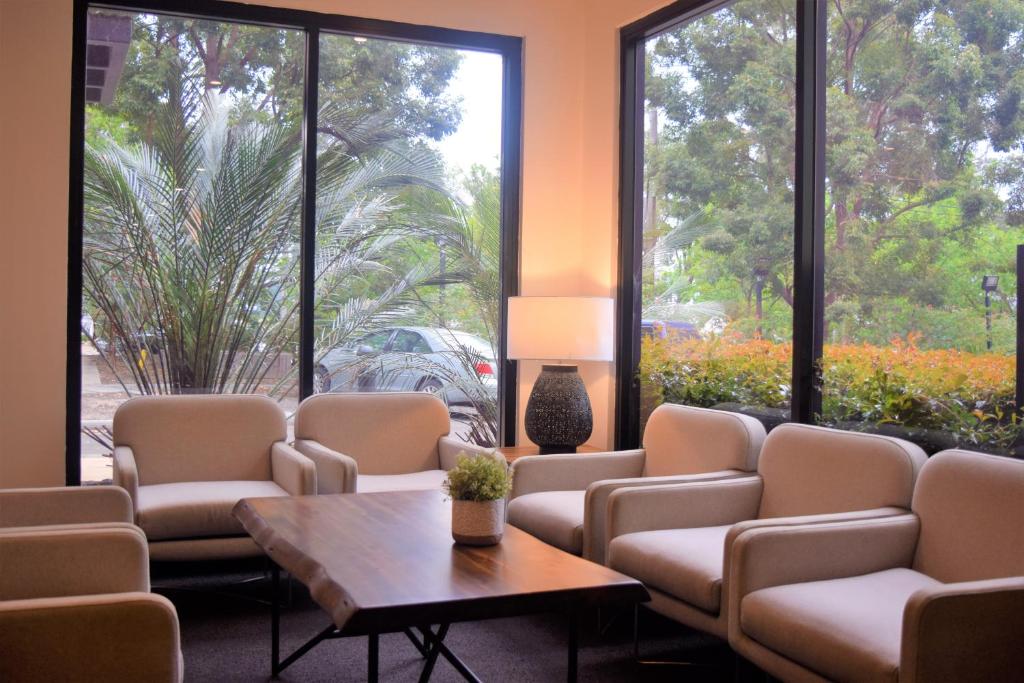 桑利宜必思索恩里酒店的一间设有椅子、桌子和大窗户的等候室
