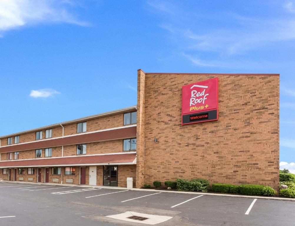 哥伦布Red Roof Inn PLUS+ Columbus - Worthington的一面有粉红色标志的建筑物