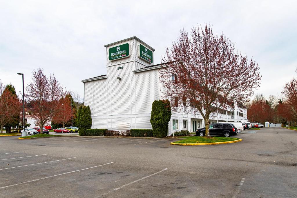 皮阿拉普HomeTowne Studios by Red Roof Tacoma - Puyallup的停车场内一座白色的建筑,有钟楼
