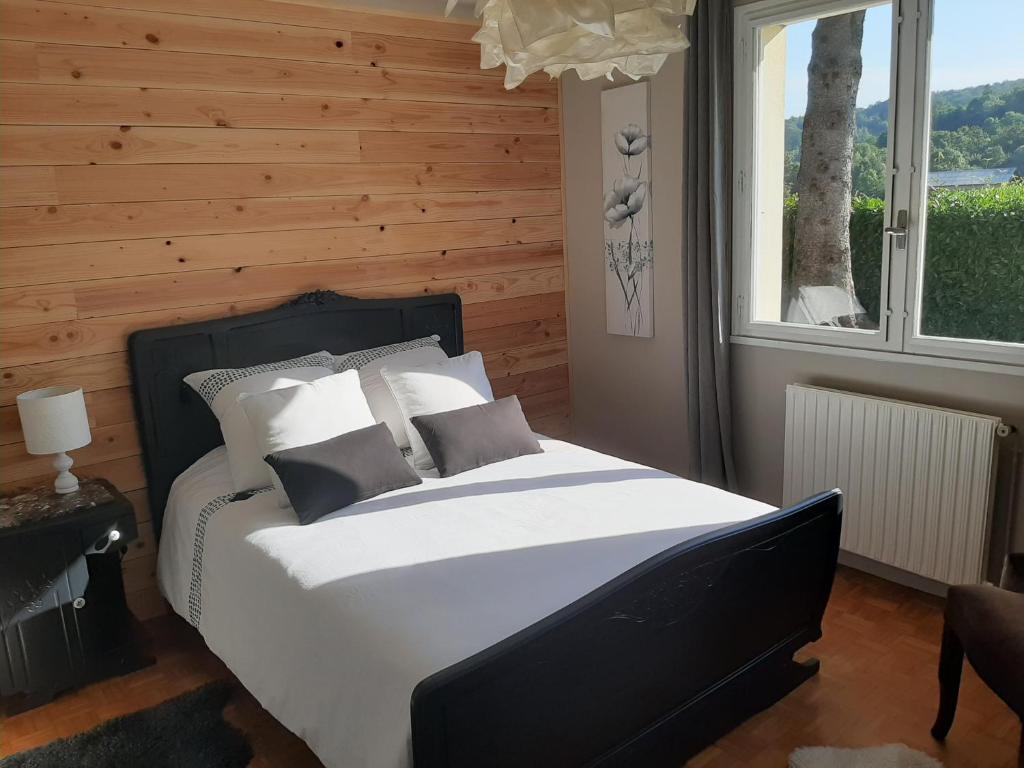 PouzacChambre Candésie的一间卧室设有一张带木墙的大床