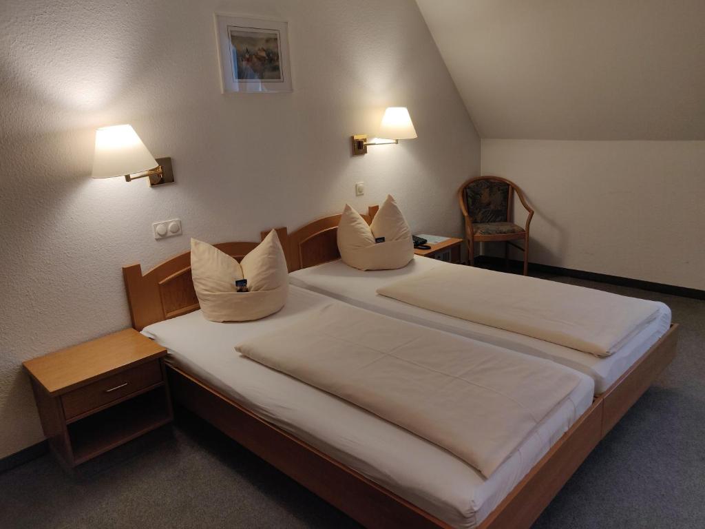 纽伦堡Landgasthof Hotel Grüner Baum的酒店客房,配有两张床和椅子