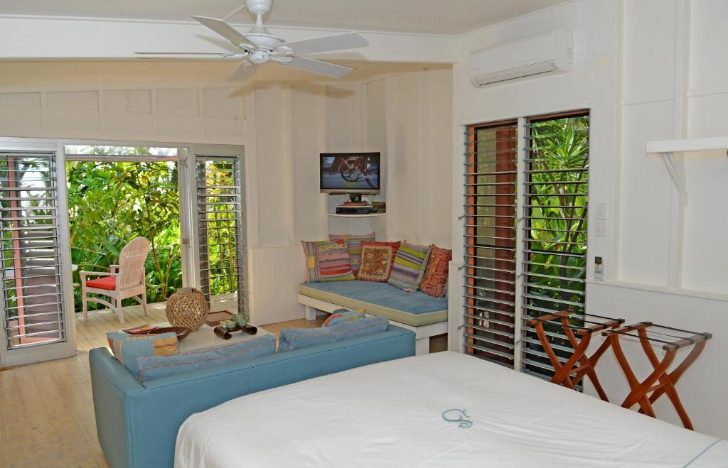 米申海滩思雅拉海滩小屋酒店的一间卧室配有一张床、一张沙发和椅子
