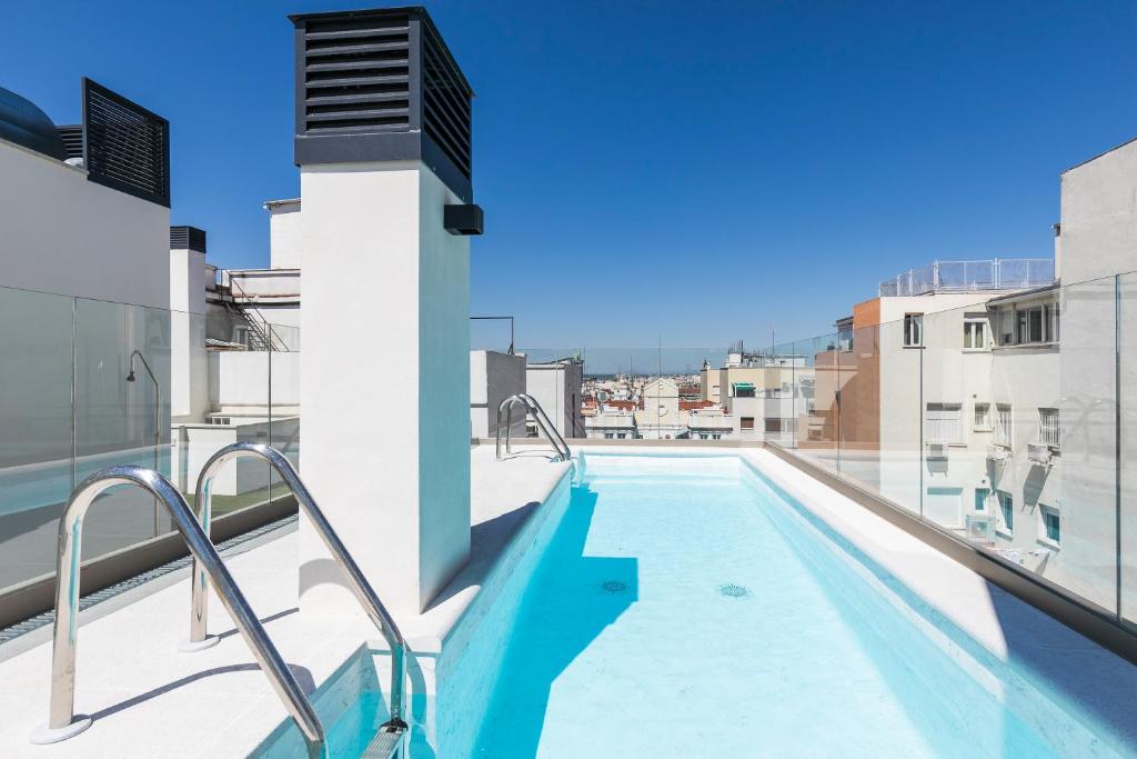 马德里Feelathome Goya Apartments的建筑物屋顶上的游泳池