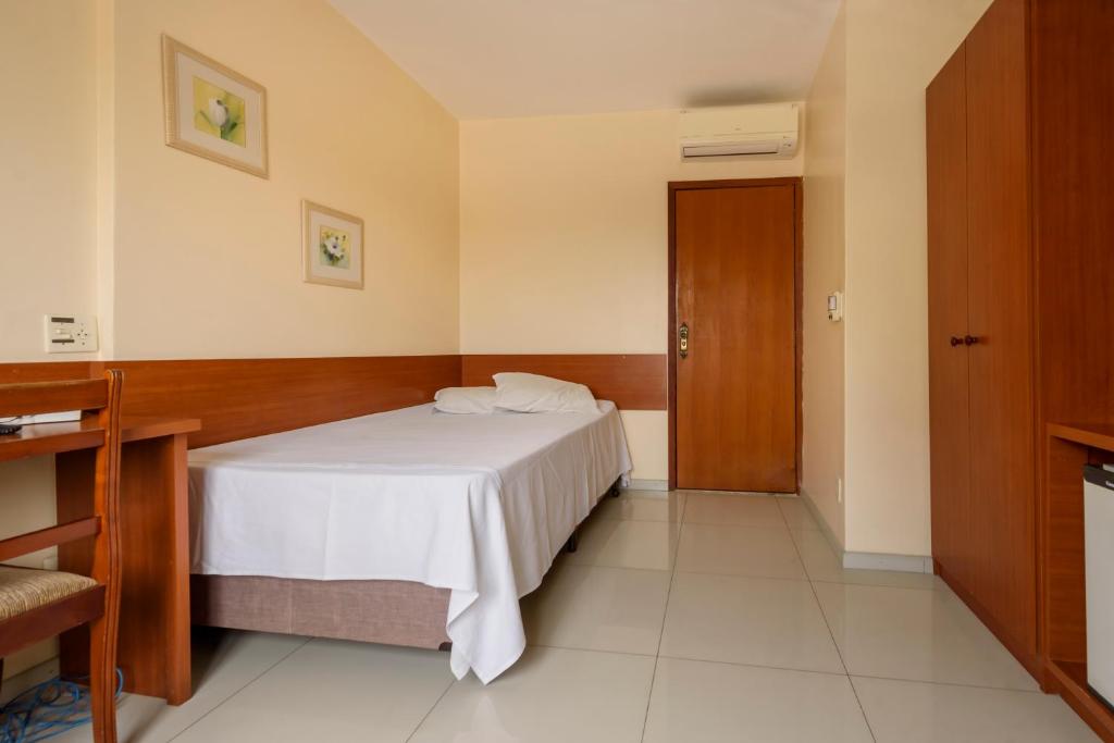 陶巴特假日套房酒店 的卧室配有白色的床和木门
