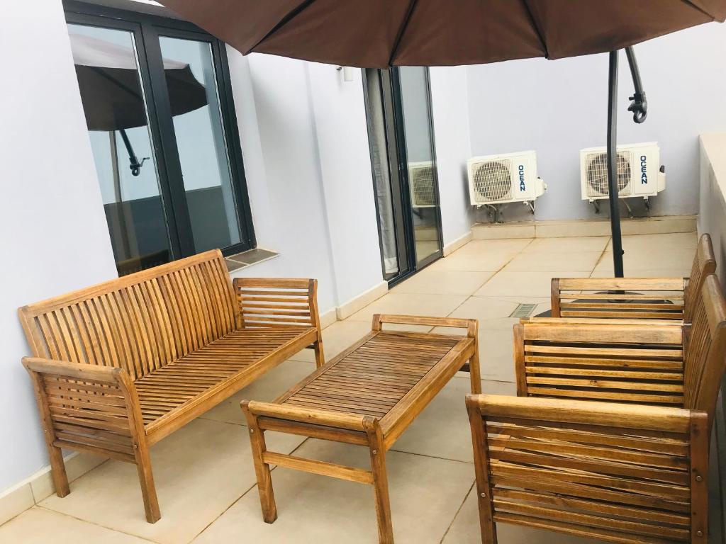 雅温得Boun's Hotel的两个木椅和一个遮阳伞